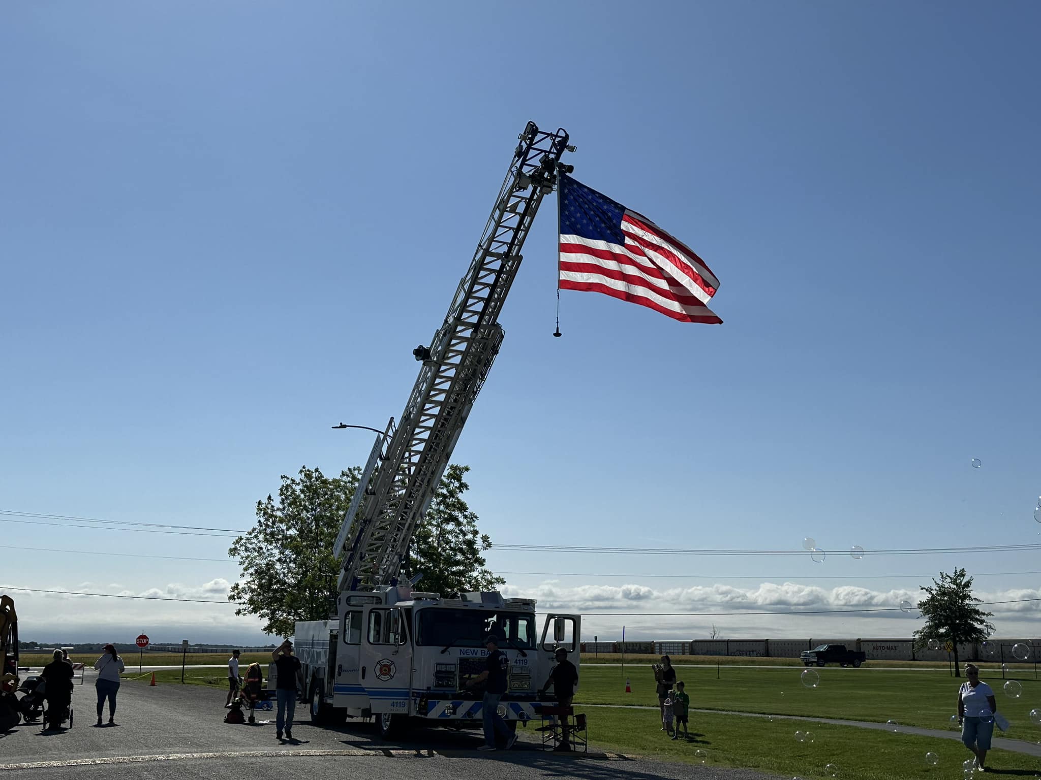 Ladder 4119 with American flag flying from the aerial at a community event